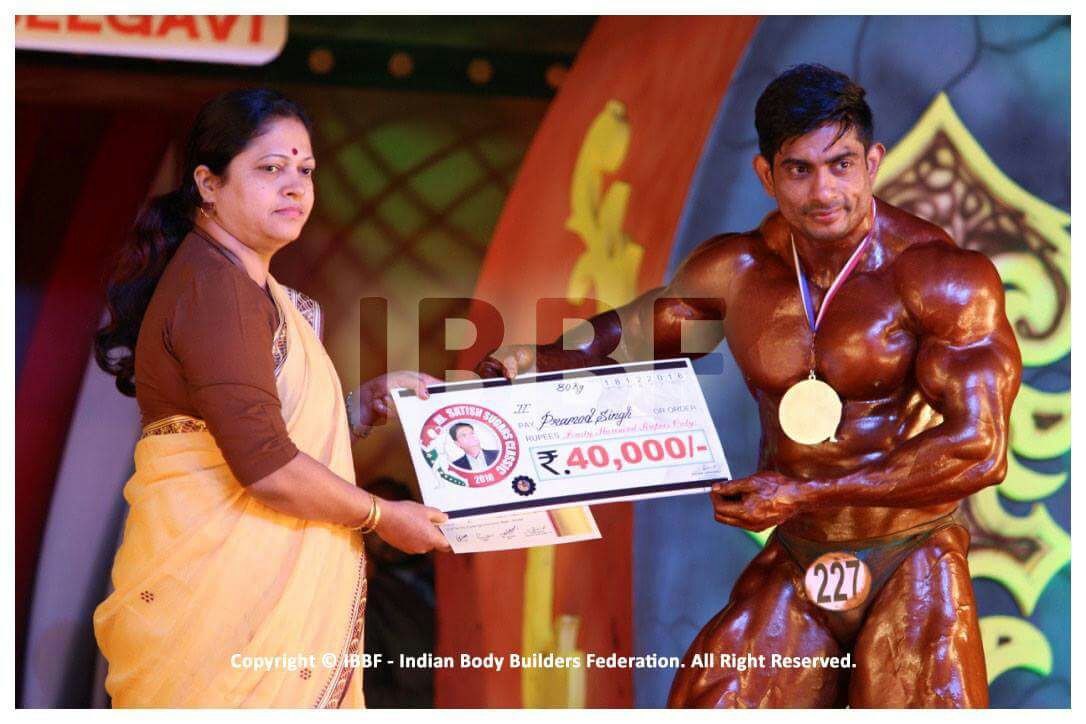 Mr. Promod Singh receiving a reward on stage during a competition